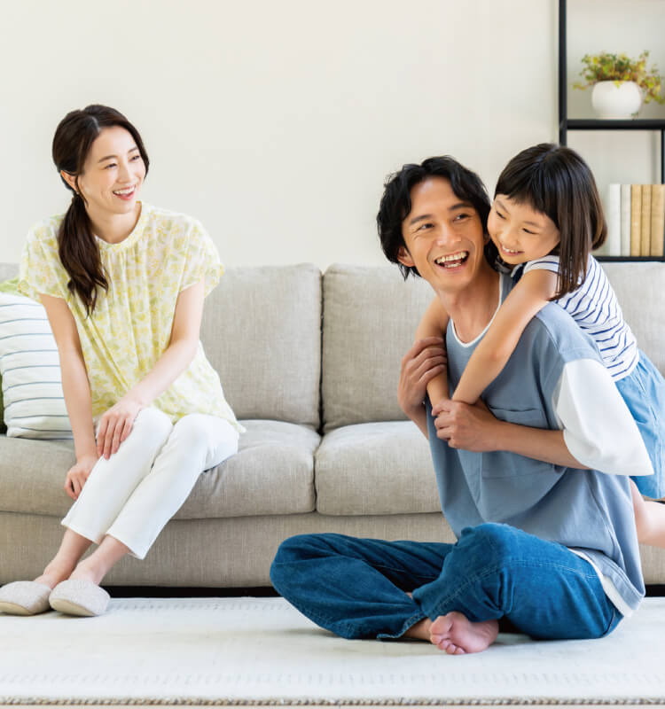 家でじゃれ合って娘と遊ぶ3人家族